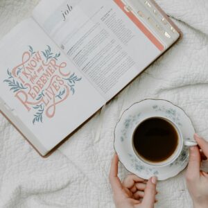 A Person Having Coffee While Reading a Book